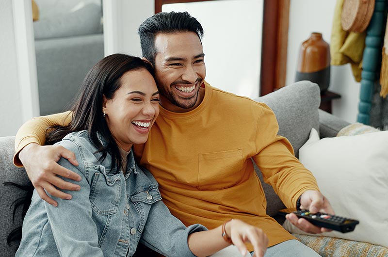 Couple laughing and watching TV