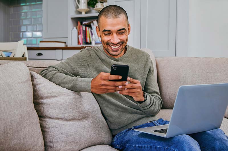 Man using laptop and cell phone